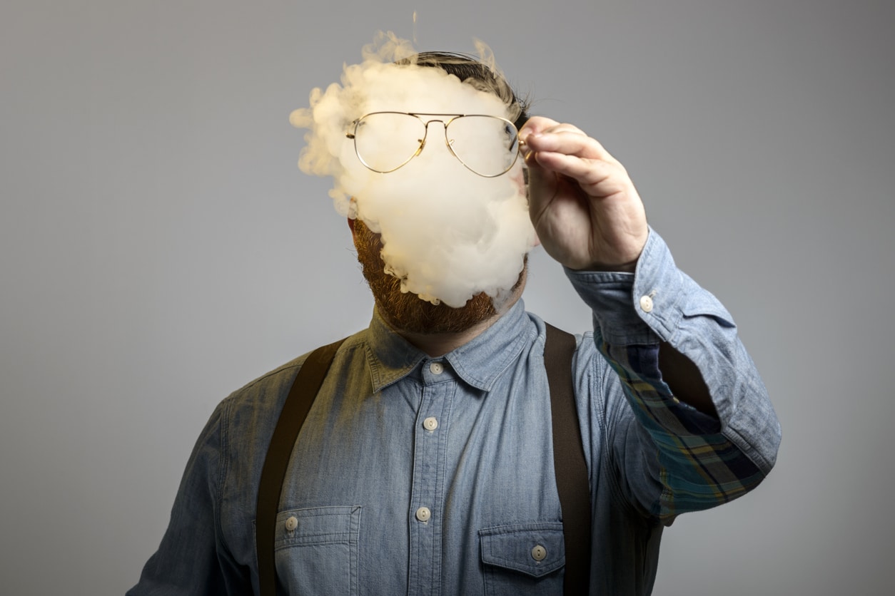 portrait of a man who is smoking an e-cigarrette