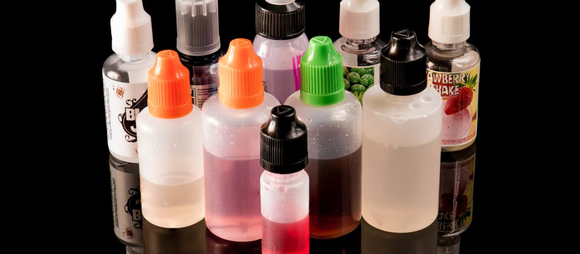 E-liquid plastic bottles on a black backdrop