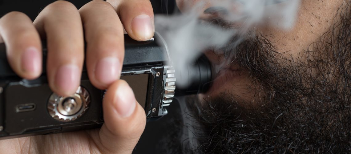 Close up of an unrecognizable young man smoking from a vaporizer